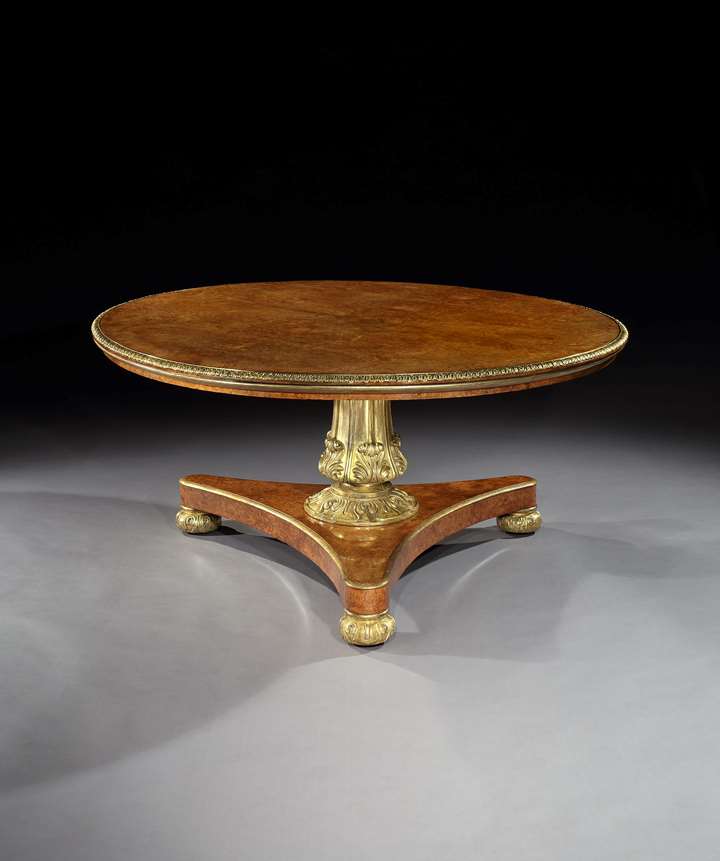 A GEORGE IV BRASS MOUNTED PARCEL GILT AMBOYNA CENTRE TABLE